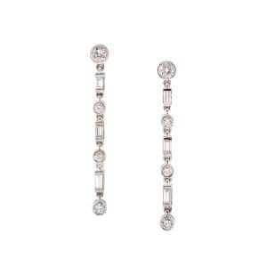 Pendientes largos de oro blanco con diamantes redondos y baguette, un diseño elegante y sofisticado que brilla en cualquier ocasión especial.