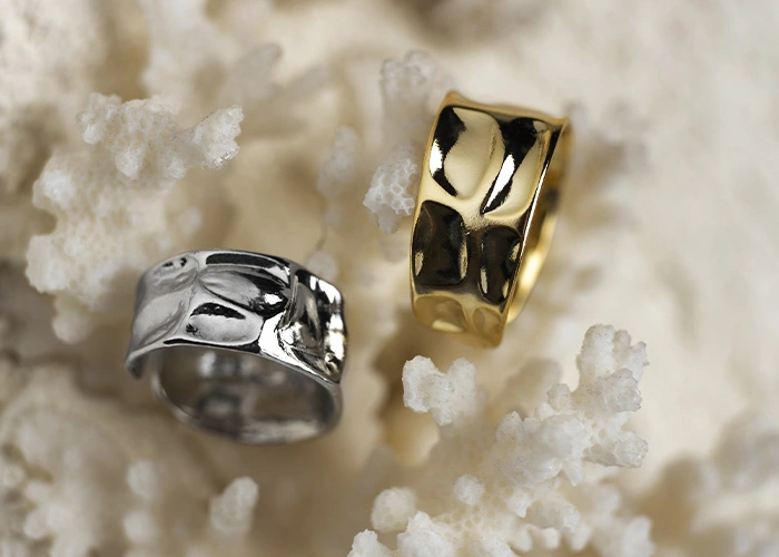 Anillos de plata y oro sobre fondo natural, razones de por qué vender joyas o enseres de plata y oro