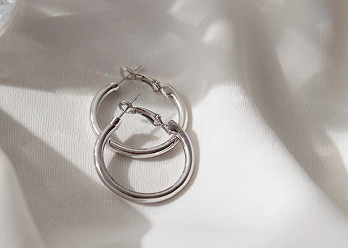 Pendientes de plata sobre tela blanca, factores que deterioran el precio de la plata