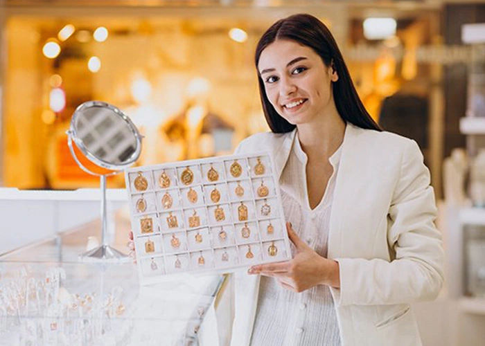 Vendedora mostrando joyas de oro en exhibición, Consejos que debes saber antes de vender oro