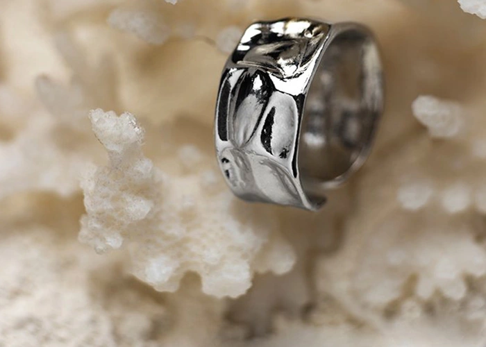 Anillo de oro blanco con diseño elegante sobre fondo de textura natural ¿Qué es el oro blanco y cuál es su propuesta de valor?