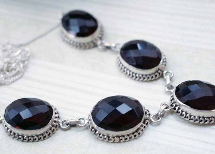 Collar de joyas de segunda mano con gemas oscuras y engarce de plata - ¿Merece la pena invertir en joyas de segunda mano?