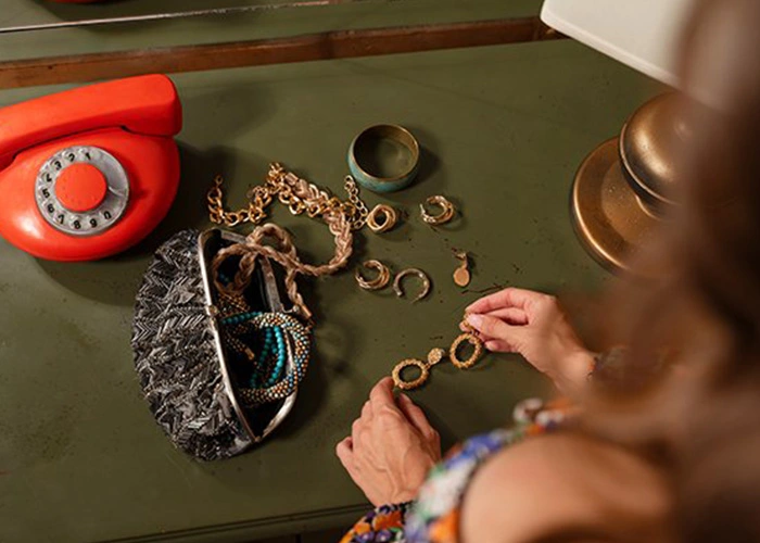 Mujer organizando joyas sobre una mesa, destacando el Impacto ambiental de la joyería de lujo